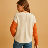 Knitted women's sweater with cable pattern and pocket detail.