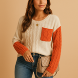 Knitted women's sweater with cable pattern and pocket detail.